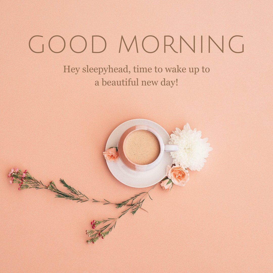 Elegant flat lay of a morning coffee setup on a soft peach background, featuring a white cup of coffee surrounded by delicate flowers and a gentle arrangement of floral sprigs, accompanied by the greeting "GOOD MORNING" and the encouraging phrase "Hey sleepyhead, time to wake up to a beautiful new day!" Ideal for sharing cute Good Morning Texts.