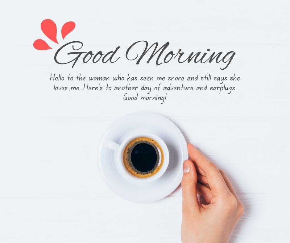 A hand holding a cup of espresso on a white wooden surface. The image includes the text 'Good Morning' and 'Hello to the woman who has seen me snore and still says she loves me. Here's to another day of adventure and earplugs. Good morning!' making it perfect for good morning messages for wife image.